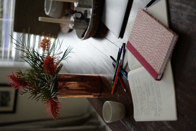 study table with book pencils and grevillea